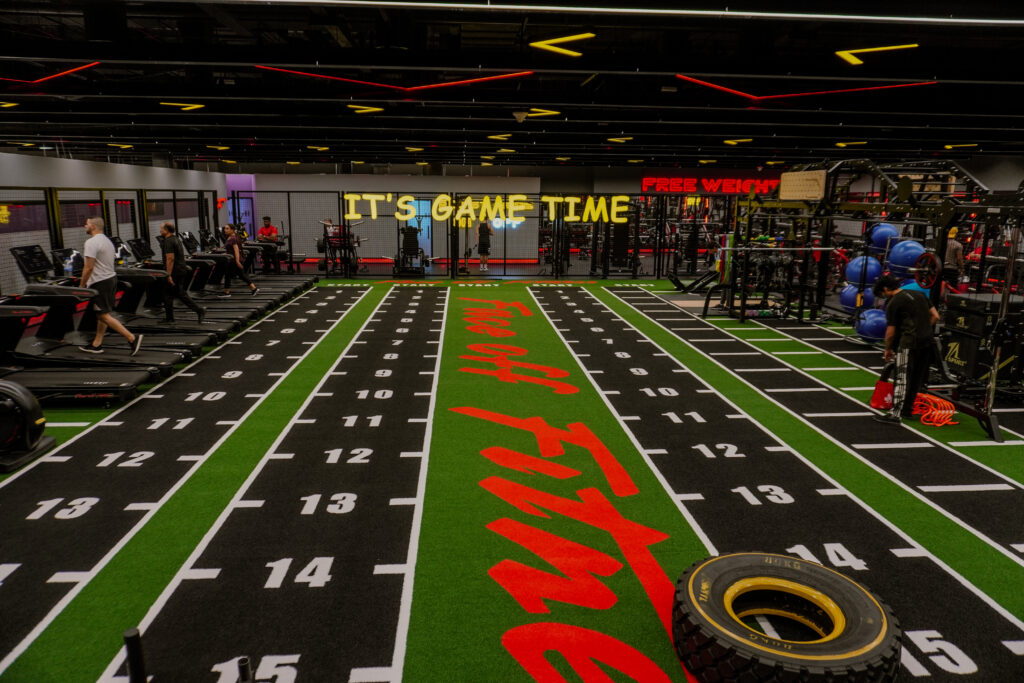 CrossFit training zones at Face Off Fitness Al Nahda Gym with athletes performing exercises.